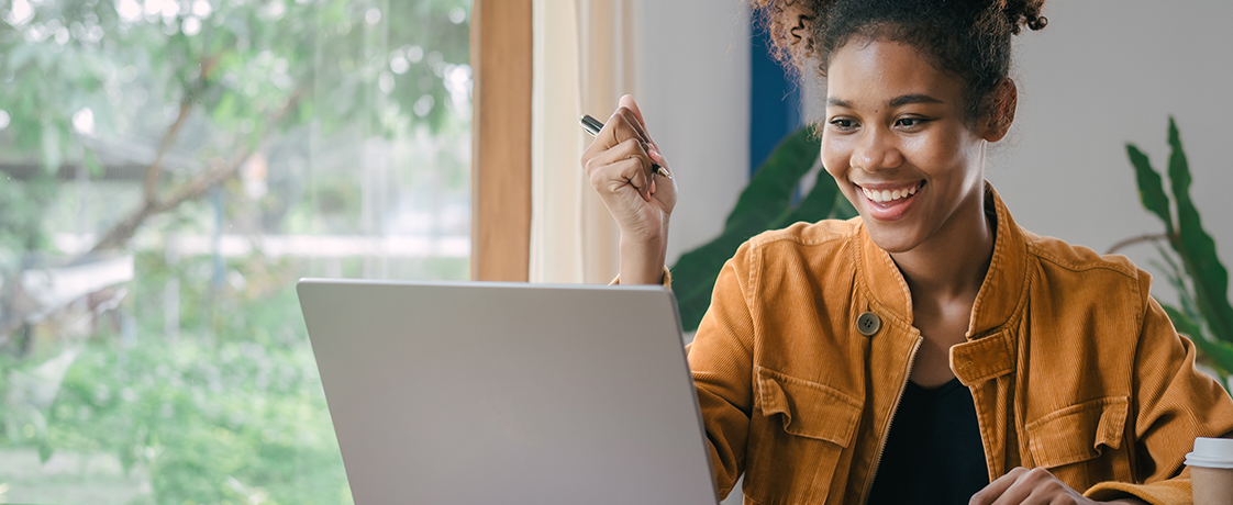 A woman smiling and using a laptop